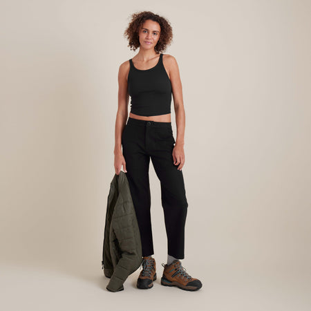 Model wearing black ribbed tank top styled with casual pants, highlighting versatile and sleek minimalist fashion.